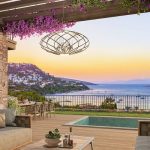 Bodrum'da Ege Denizi manzarasına karşı, özel havuzlu ve begonvillerle süslü lüks villa terasında gün batımı keyfi.