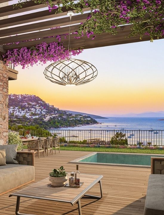 Bodrum'da Ege Denizi manzarasına karşı, özel havuzlu ve begonvillerle süslü lüks villa terasında gün batımı keyfi.