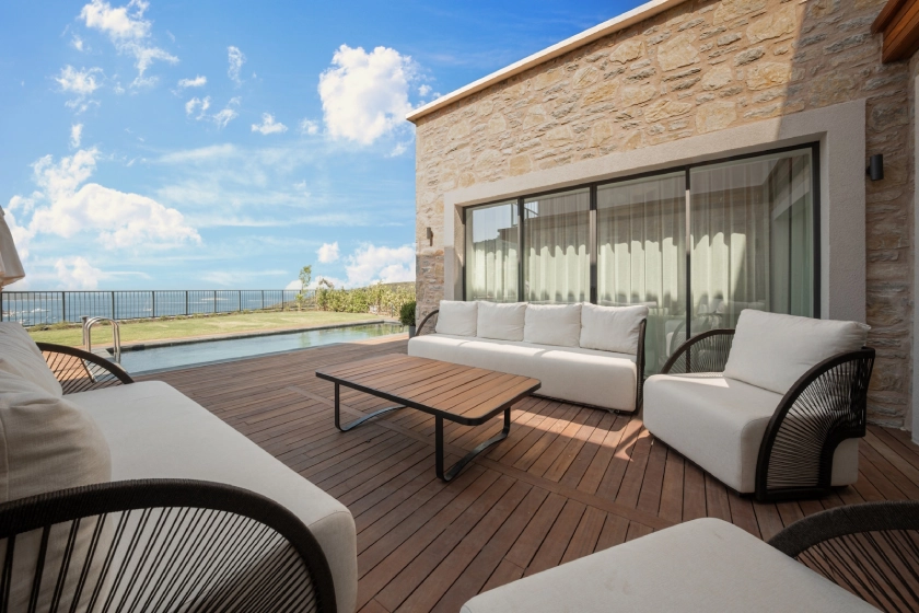 Gift Hebil projesindeki Bodrum Hebil Koyu satılık villa seçeneklerinde yer alan lüks villanın bahçe oturma alanı ve havuz manzarası, doğayla iç içe Bodrum satılık lüks villa yaşamını yansıtır.